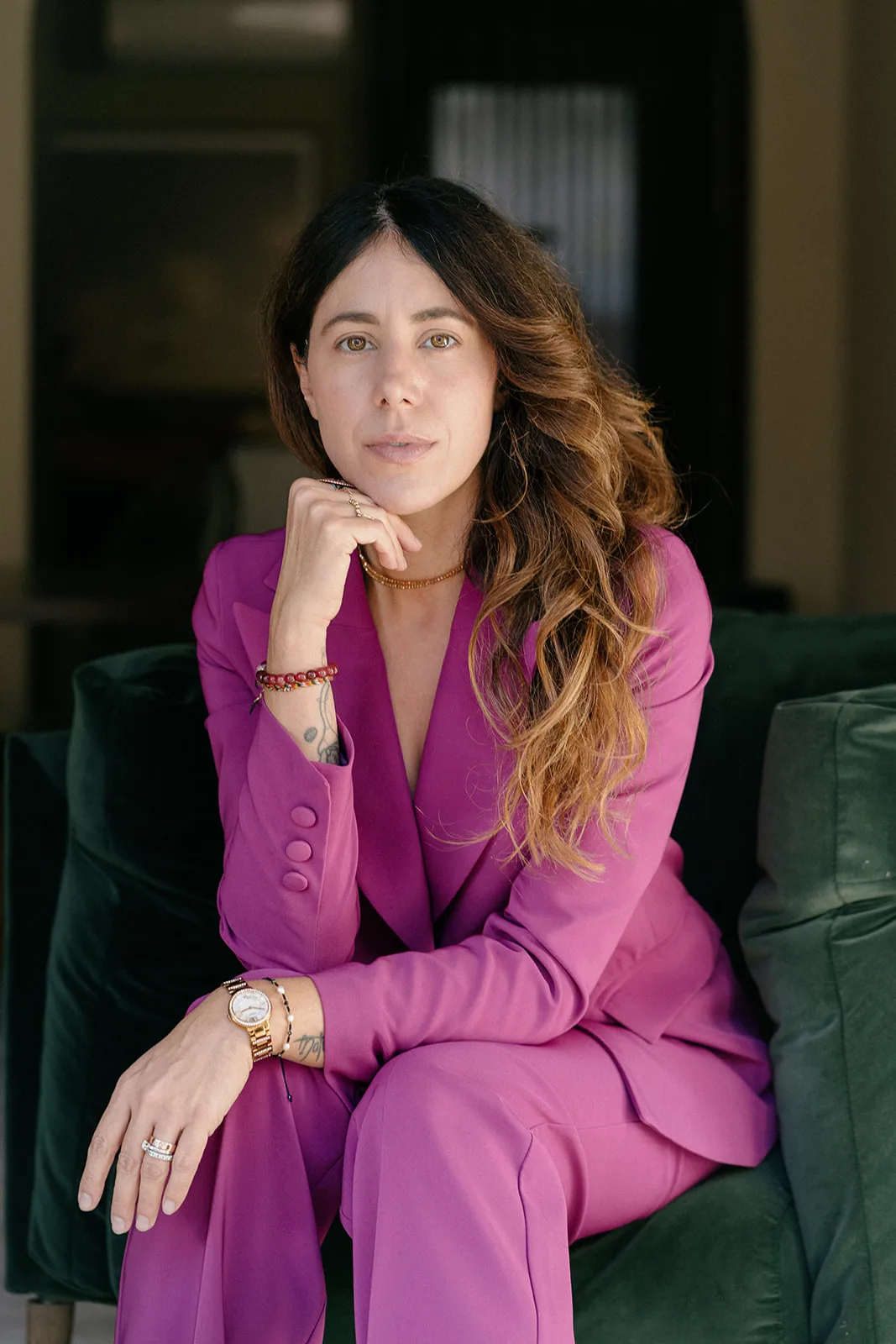 Federica in blazer magenta su poltrona verde